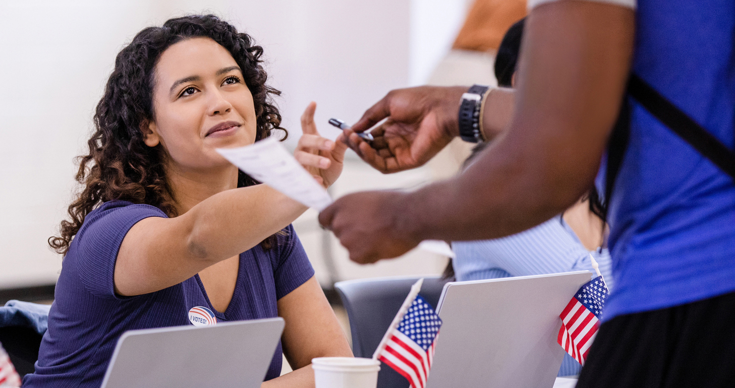 Female poll worker helping a voter.