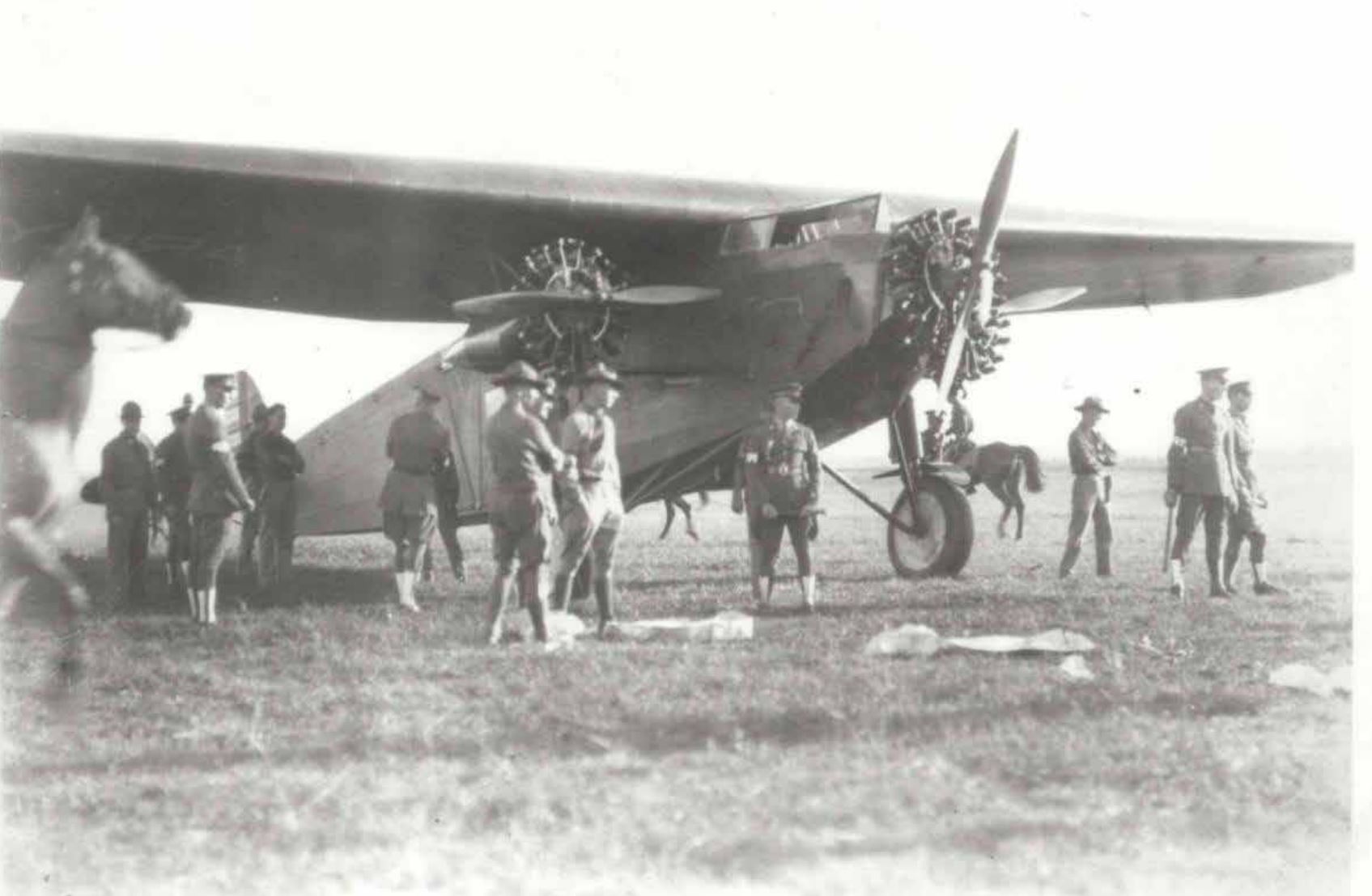 A photo of an airplane with soldiers around it. The plane is called the Bird of Paradise