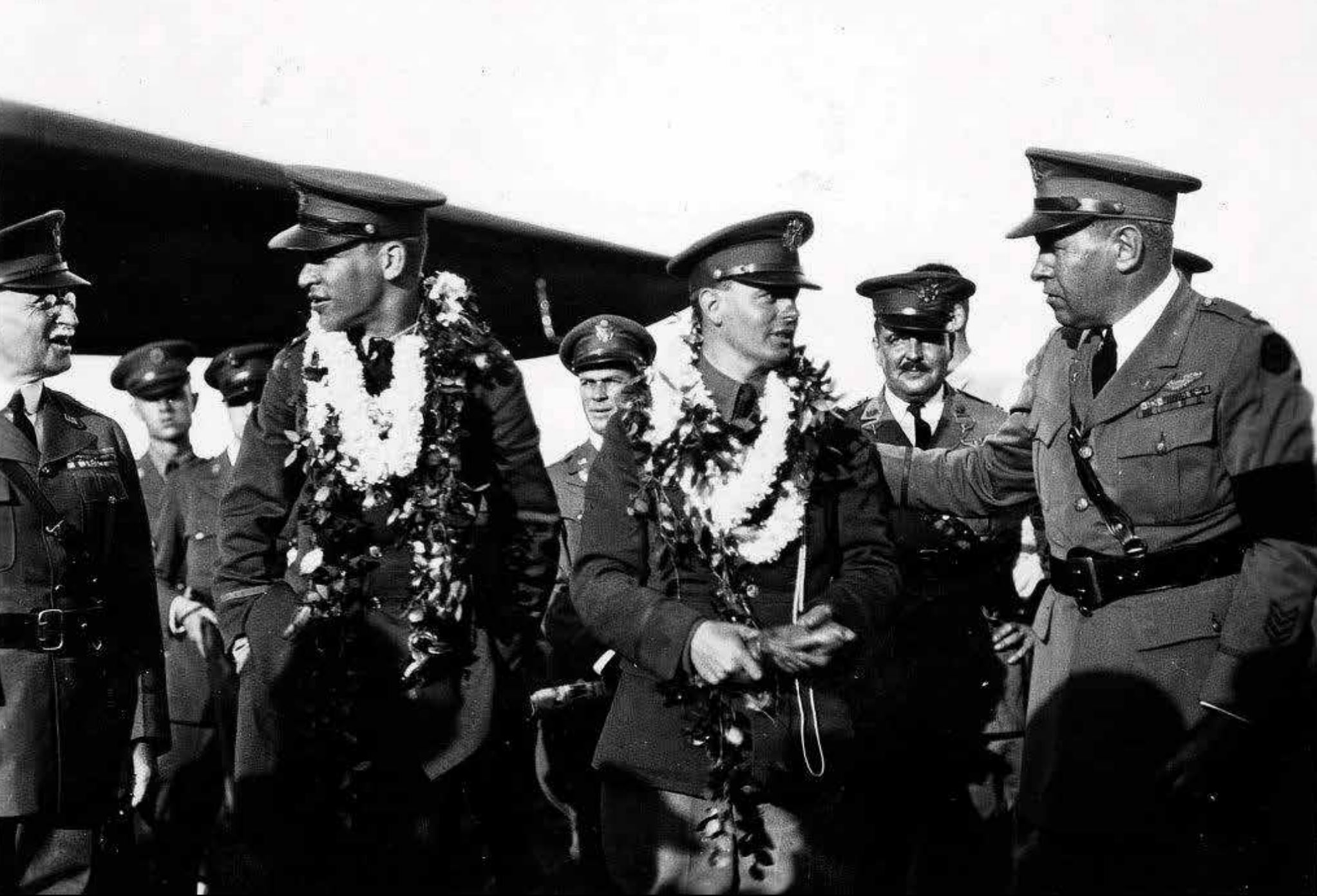 A photo of a group of airman and military leadership. The photo is captioned Lt. Lester J. Maitland and Lt. Albert F. Hegenberger (right) received a hero’s welcome in Hawaii after their trans-Pacific flight. Hegenberger later retired as a Major General. 