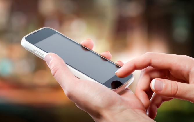 Protect yourself from the grandparent scam photo illustration of someone's hands using a smart phone. 