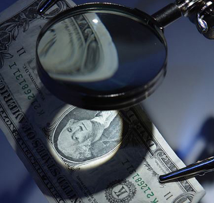 Graphic of a magnifying glass over a dollar. George Washington's image is in the central focus. 