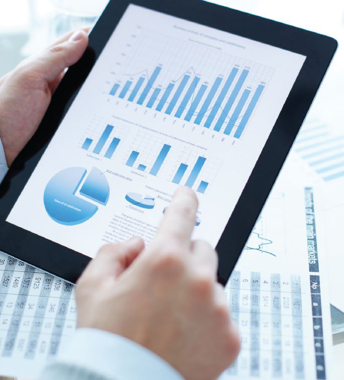 An image of a man using his touchscreen device that has images of charts on it. 